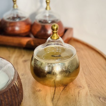 مضيفة نحاس وسط غطاء زجاج 