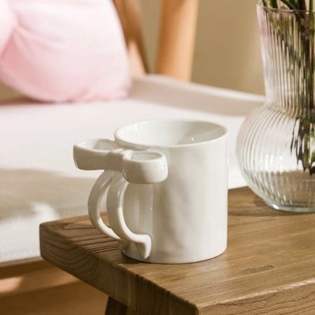 مج سيراميك أبيض مع يد على شكل فيونكة