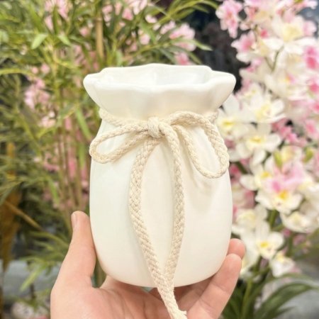 مزهرية بلاستيك بيضاء مزينة بحبل